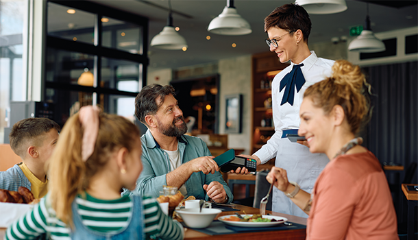 Family at restaurant paying bill